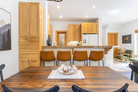 The view from the dining table towards the kitchen. The two spaces are connected via a kitchen bar which includes 3 bar stools.