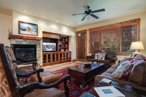 Sink into plush leather seating by your crackling fireplace, where warm wood tones and mountain views create the perfect alpine retreat.