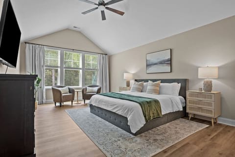 Large master bedroom, with TV and two lounge chairs. There is also a Pack `n Play for toddlers.