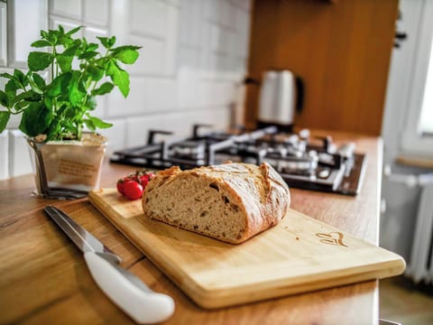 A close-up of fresh bread on a cutting board with basil, adding a cozy, home-like touch to the kitchen.
