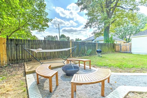 fire pit and benches in backyard patio, plus hammock and grill