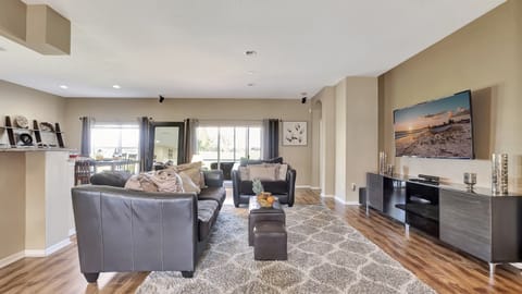 Oversized windows flood the room with natural light, offering sweeping views of the outdoors.