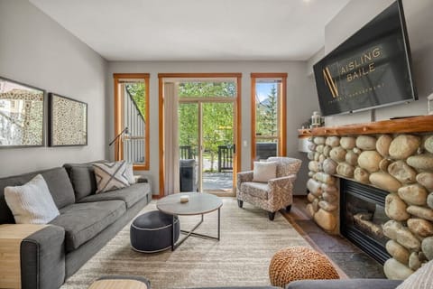 Main floor living room with a gas fireplace, Smart TV, cozy seating options and walkout access to the deck space.