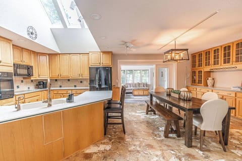 Open-concept kitchen and dining area with a bright Carolina room leading to the outdoor deck. Ideal for post-round meals and relaxing or grilling out.