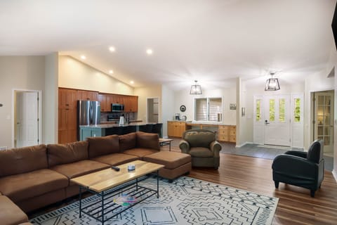 Main floor living room looking at the kitchen and door to the master bedroom