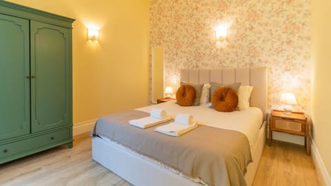 Retreat to this serene bedroom designed for ultimate comfort, featuring a plush bed and ample storage in the charming green wardrobe, ensuring a restful and organized stay. The warm lighting and thoughtful decor provide a peaceful haven after a day of adv