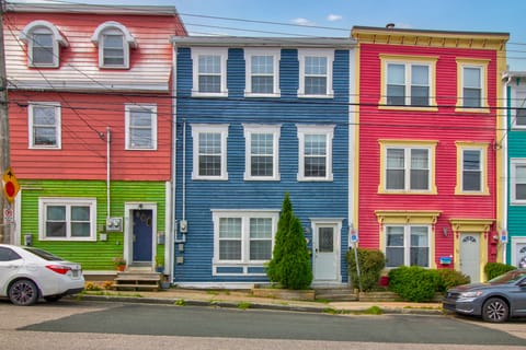 The houses are lined up in a row, with a cohesive architectural style that creates a harmonious look along the street.  The pristine street features clean sidewalks, well-maintained roads, and ample parking spaces along the curb, creating a tidy, organized atmosphere with well-kept houses that offer a welcoming, peaceful environment for residents and visitors.