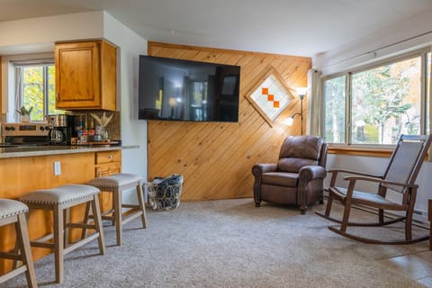 65" Smart TV & recliner in living area.
