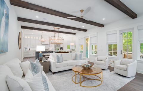 Sink into plush seating surrounded by coastal blues and warm wood beams, where your open-concept living flows seamlessly into the chef's kitchen.