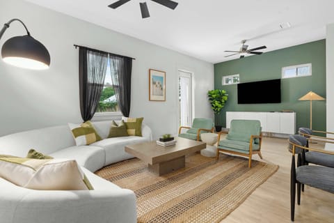 Open-concept living room with plush seating, large windows, and a cozy atmosphere—perfect for family relaxation or movie nights. - The Sandbar - Panama City Beach, FL