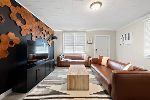 The hexagonal wooden panels surrounding it create a geometric harmony, adding visual interest to the minimalist decor. Through the window, sunlight filters gently, casting warm patterns on the floor.