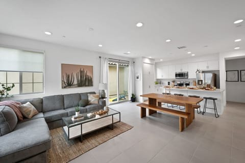 Bright open living space w/ cozy sofa seating flowing into dining & kitchen areas