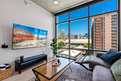 An awesome leather recliner is grBeautifully designed living room. 65` TV, leather sofa and amazing views of mountains and city skyline.eat for relaxing and taking in the view.