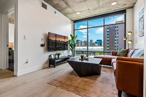 Beautifully designed living room. 65` TV, leather sofa and amazing views of mountains and city skyline.