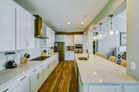 Large fully stocked kitchen with huge island, new stainless steel appliances, and large pantry.