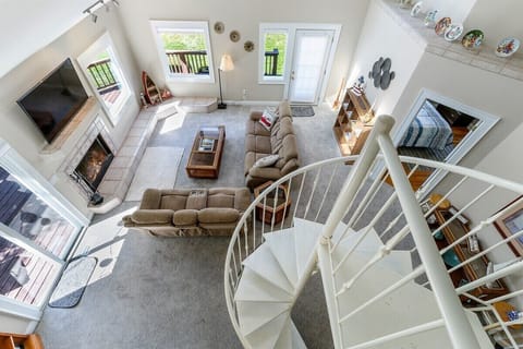 View from top of spiral stairs of living room with smart TV