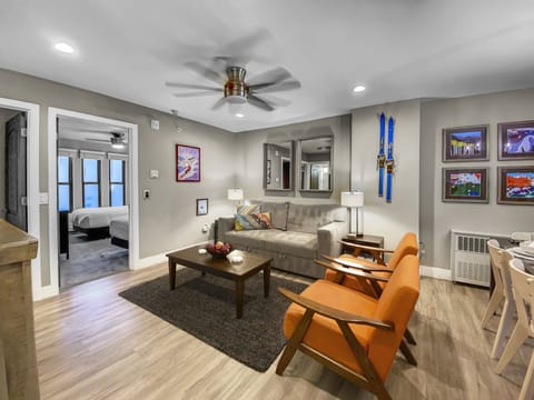 Stylish living room with modern décor, cozy seating, vibrant accents, and ski-inspired artwork. Perfect for relaxing after exploring Park City. Bright, inviting, and designed for comfort.