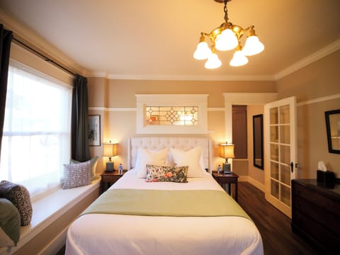 Wake up refreshed in this inviting bedroom, adorned with stained glass details and plush bedding for a truly restful stay