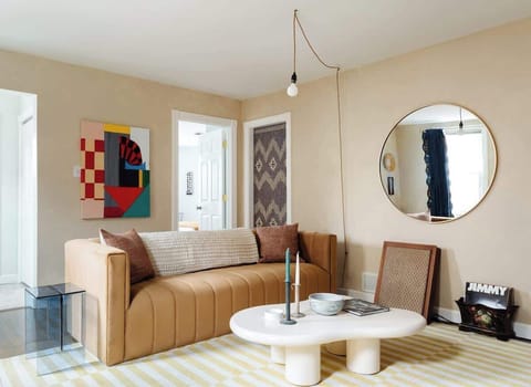 Bright living room with two way adjustable blinds and curtains for optimal light and privacy. There is a large comfortable velvet couch as well as mood lighting. The space has an awesome sound system and record player. Smart TV.