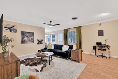 Living room with cozy couch, TV, and dedicated workspace 