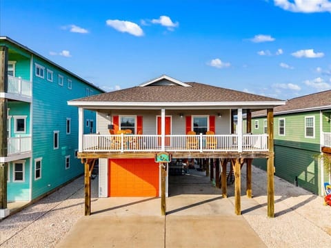 Bright coastal home with a spacious covered porch and plenty of parking beneath.