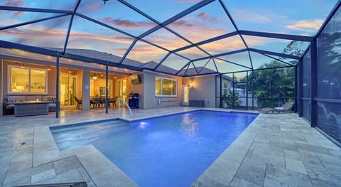 Relax on the pool sundeck, with modern travertine tile and color-changing lights