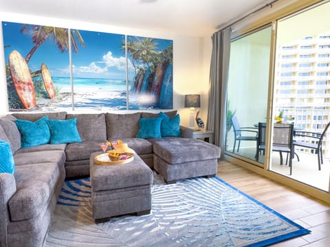 Relax in this modern living room with ocean-themed decor and balcony access.