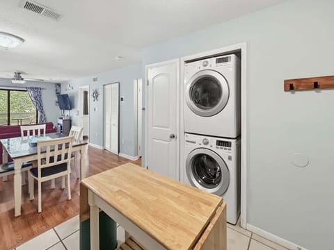 A dedicated laundry nook houses a modern, stacked front-loading washer.