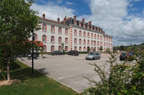 Discover the charm of this spacious parking area, surrounded by lush greenery and classic architecture.