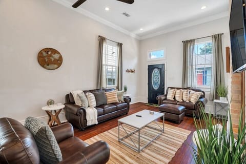Bright living room w/ leather sofas & classic hardwood floors.
