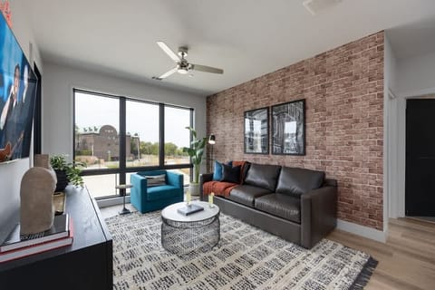 Inviting designer furnished living space featuring a comfortable sleeper sofa, a Smart TV for entertainment and a private covered balcony.