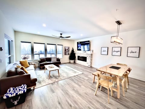 Open living room with electric fireplace and large smart TV with cable