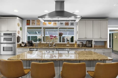 Open kitchen with bar and stools facing the pool area