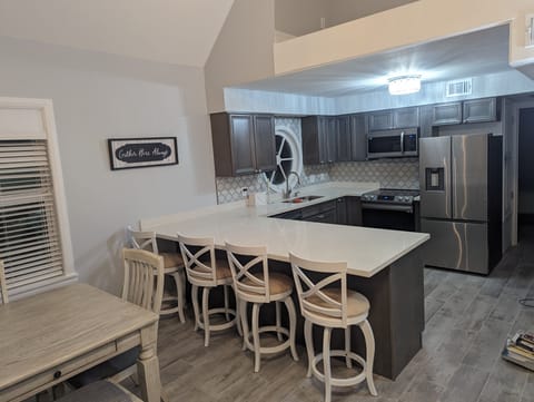 Dining/Kitchen view with chairs to seat 10 people (table + bar)