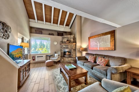 Cozy up by your crackling fireplace with mountain views streaming through large windows in this warm, timber-beamed living space.