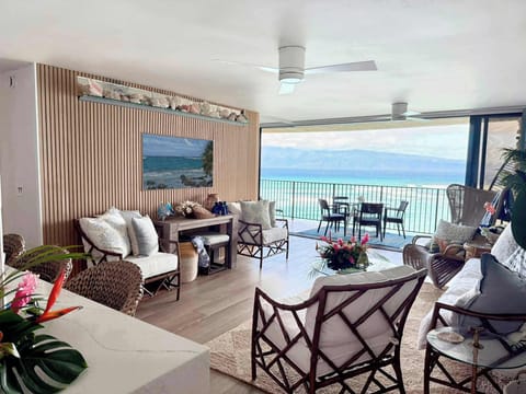 Ocean views throughout! Entry view past kitchen looking over the living room with wide slider doors leading to the expansive lanai providing a seamless indoor and outdoor space.