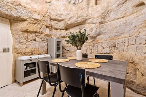 Unique dining area set against original stone walls, combining modern comfort with centuries-old charm for a truly memorable stay.