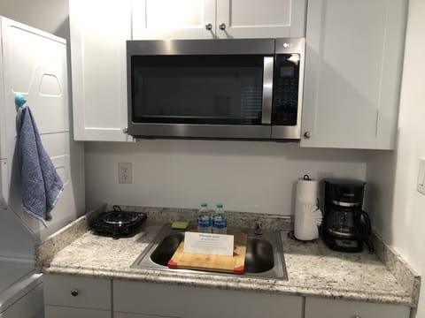 Kitchenette with microwave, burner, sink, coffee maker