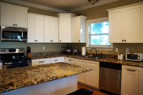 Kitchen with granite counter tops, coffee maker and hot water kettle