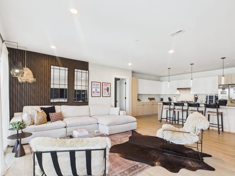 Cozy modern living room featuring a Smart TV, Patio access with city views and designer decor with plush furnishings.