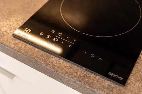 A sleek induction cooktop on a gray countertop, highlighting a clean and contemporary kitchen design.
