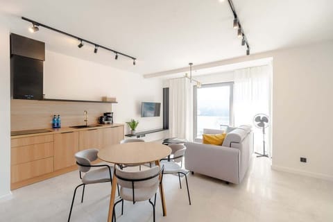 Another angle of the living and dining area, emphasizing the natural light and clean layout.
