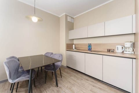 A dining area with a modern table, chairs, and a pendant light, designed for comfort and style.

