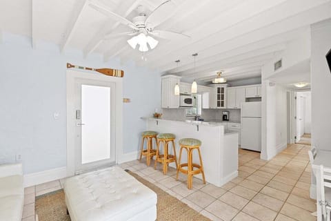 Full kitchen with bar stools, TV, and cozy nooka perfect space for cooking and casual dining.