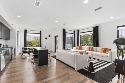 Open floor plan from the kitchen to living room, equipped with new furnishings, plenty of natural light, and the balcony overlooking the Cumberland river.