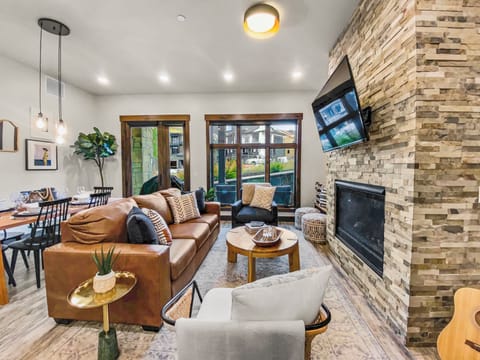 Sink into plush leather sofas beside a glowing fireplace, where mountain views on the screen and warm lighting invite you to unwind in modern comfort.