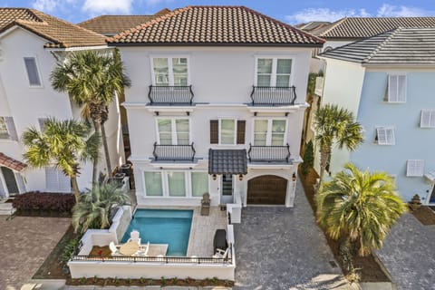 Elegant Mediterranean-style property featuring private pool and tropical landscaping in an upscale beachside neighborhood.