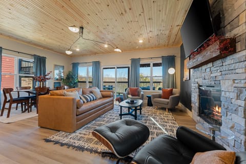 Charming Living Room: Sunlit retreat with elegant seating, a warm fireplace, and scenic views!