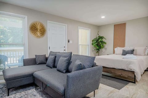 Modern studio with cozy lounge seating and a plush bed — perfect for relaxing after a day out. Natural light, stylish decor, and comfort all in one space.