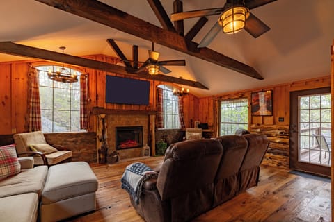 Rustic living room with fireplace, big TV, and comfy seating!